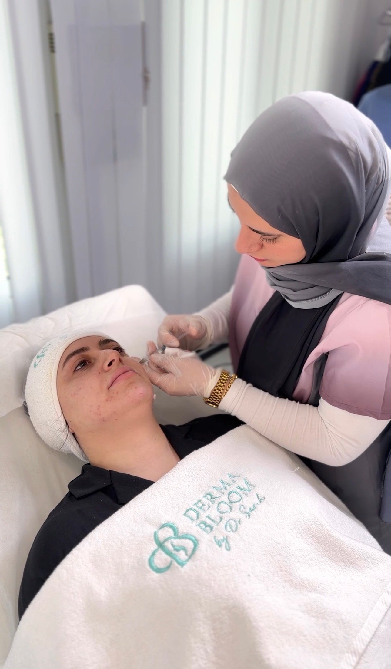 طبيب يعالج مريضة في مركز ديرمابلوم الطبي بمردف، دبي